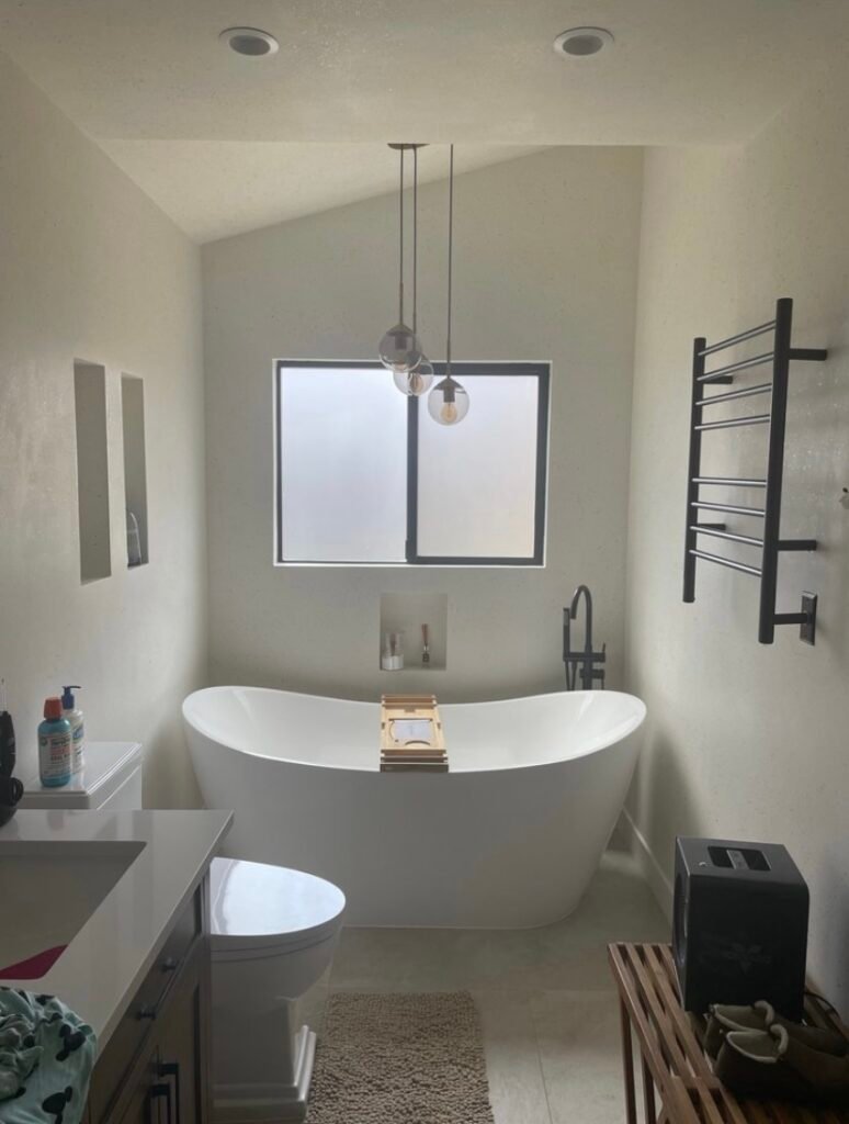 Luxury spa bathroom remodel featuring a freestanding soaking tub, walk-in shower, floating vanity, quartz countertops, and modern designer finishes.