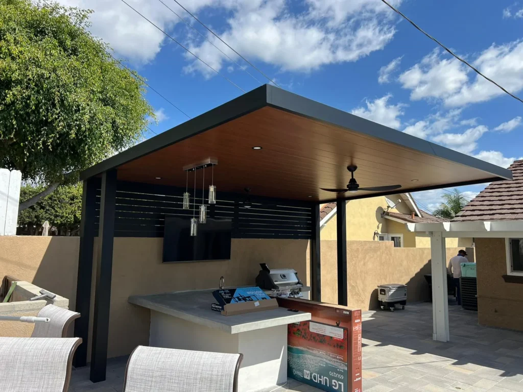 Covered backyard patio with a modern pergola and outdoor kitchen area, remodeled by DC Home Renovations in Los Angeles.