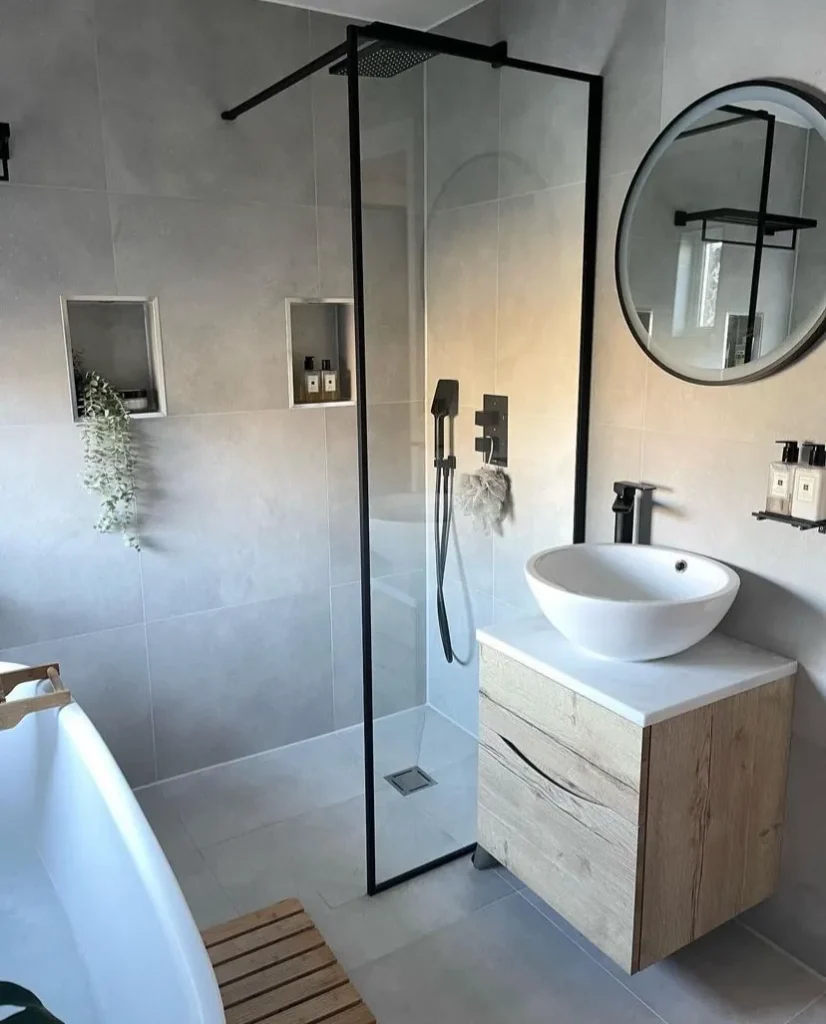 Bathroom with a walk-in shower, round mirror, vessel sink, and freestanding tub, remodeled by DC Home Renovations in Los Angeles.