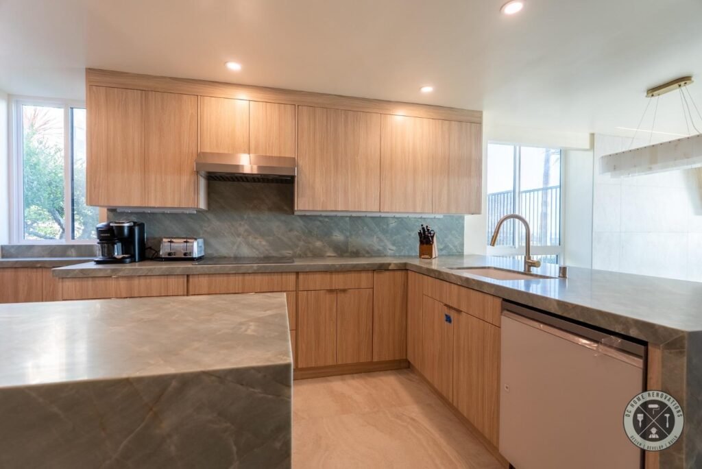 Modern kitchen remodel in Orange County featuring custom wood cabinets, quartz countertops, tile backsplash, and stainless steel appliances.