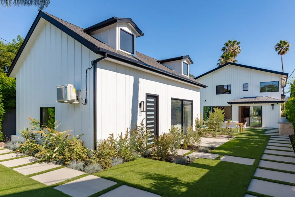 Modern farmhouse home exterior with white siding and fresh landscaping, remodeled by DC Home Renovations in Los Angeles.