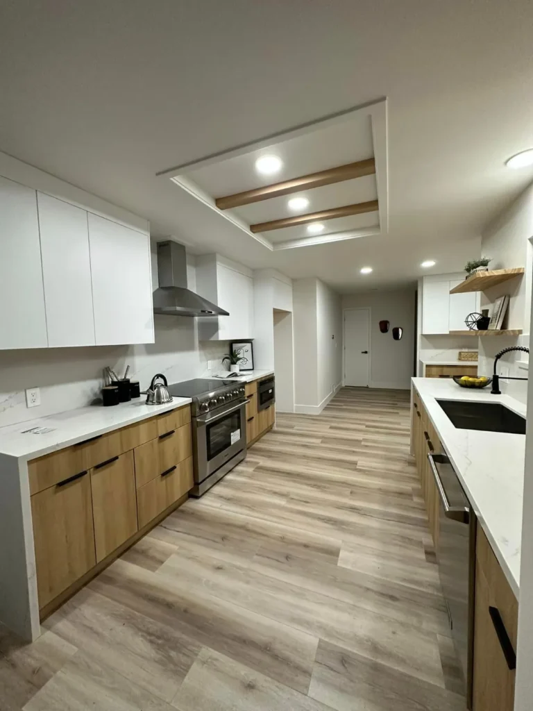 Wood-cabinet kitchen with white quartz counters, a gas range, and wood floors, remodeled by DC Home Renovations in Los Angeles.
