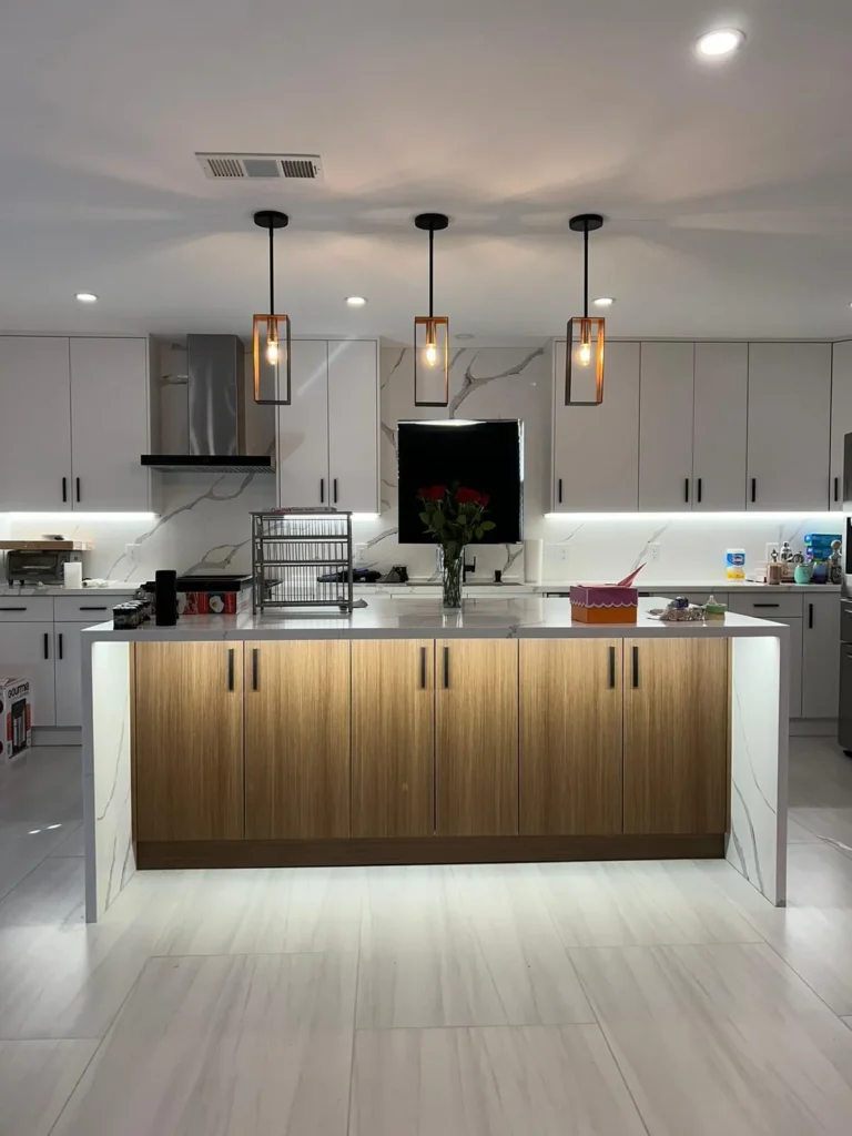 Modern kitchen with a wood island, marble counters, and pendant lighting, remodeled by DC Home Renovations in Los Angeles.