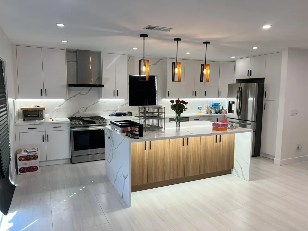 Open kitchen with a wood island, marble counters, and modern pendant lights, remodeled by DC Home Renovations in Los Angeles.