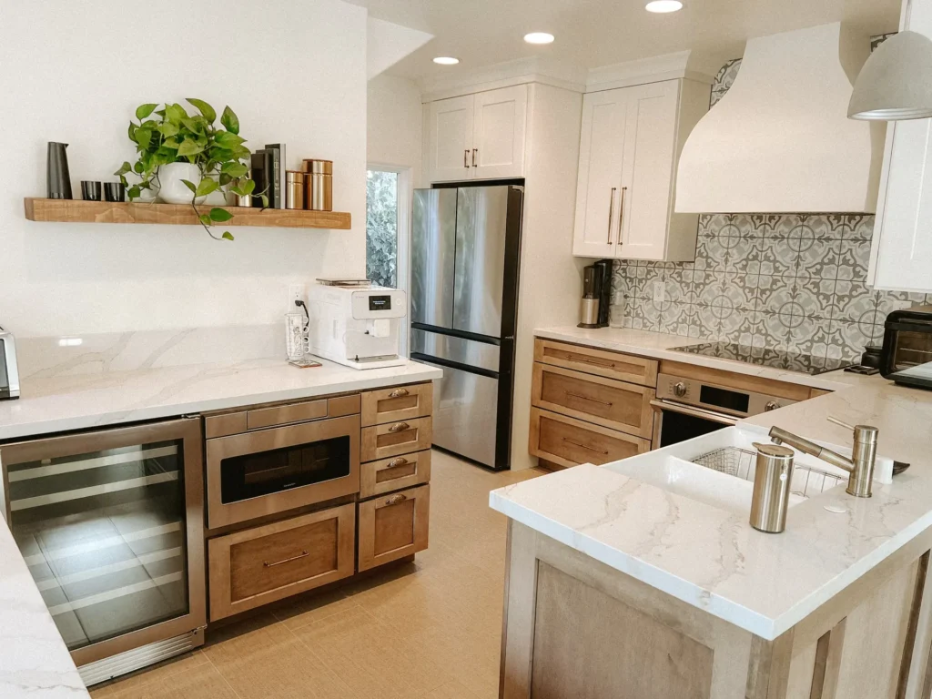 Warm wood kitchen with a wine fridge, marble counters, and a floating shelf, remodeled by DC Home Renovations in Los Angeles.